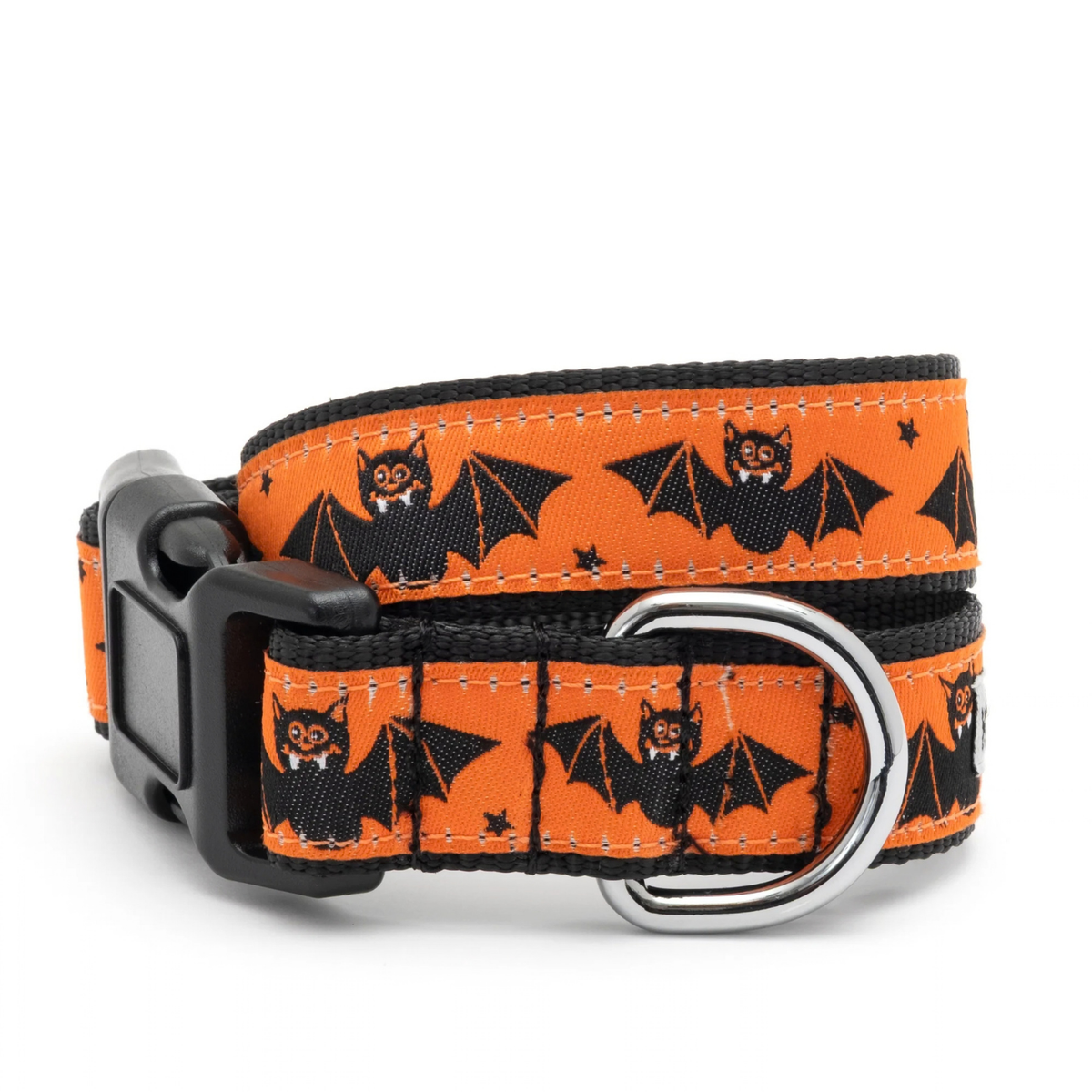 An orange dog collar with a black buckle and silver metal ring, featuring a repeating pattern of black bats with cartoon faces and small black stars.