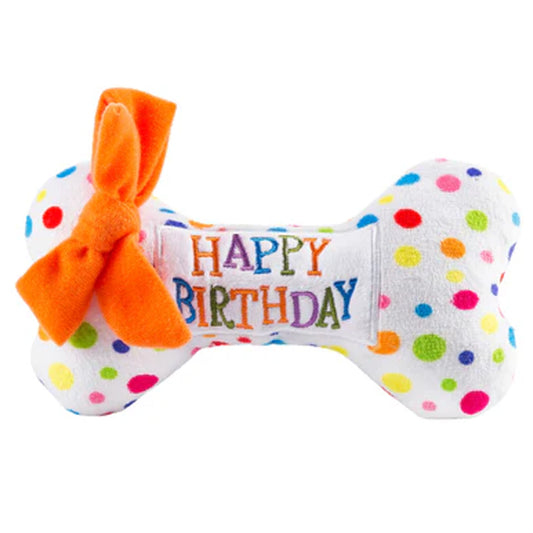 Polka dot dog toy with 'Happy Birthday' text and orange bow on a white background