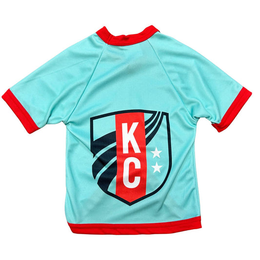 Light blue sports jersey with red accents and 'K C' logo on a white background