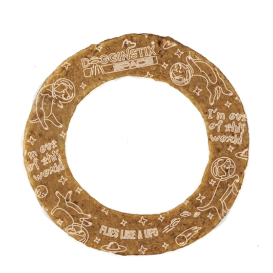 A circular brown dog collagen bone with engraved white cartoon illustrations and text, including 'DOGINS bonTIX' and 'FLEES LIKE A UFO', shown on a plain white background.